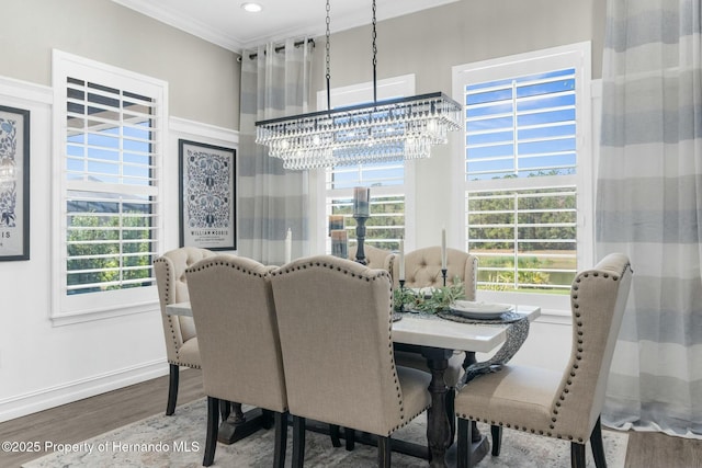 dining room with an inviting chandelier, baseboards, ornamental molding, and wood finished floors