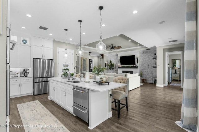 kitchen with a warming drawer, ornamental molding, a sink, and freestanding refrigerator