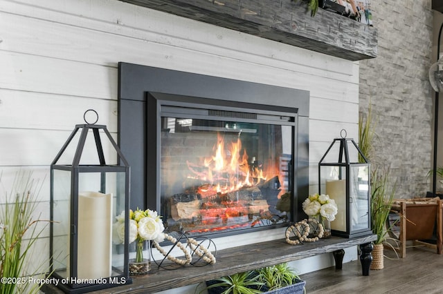 room details with wood finished floors and a glass covered fireplace