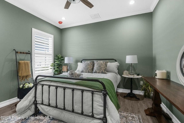 bedroom with visible vents, baseboards, wood finished floors, and ornamental molding