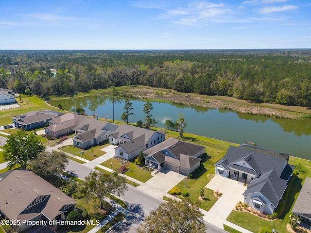 drone / aerial view with a water view, a wooded view, and a residential view