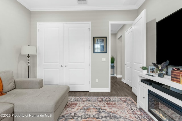 interior space with ornamental molding, dark wood-type flooring, visible vents, and baseboards