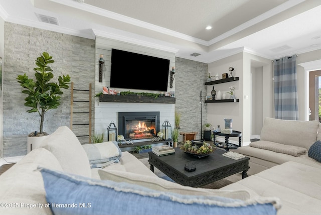 living area featuring visible vents, ornamental molding, a tray ceiling, a fireplace, and recessed lighting