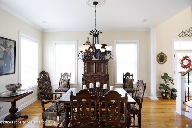 dining area featuring light wood finished floors, decorative columns, a chandelier, and baseboards