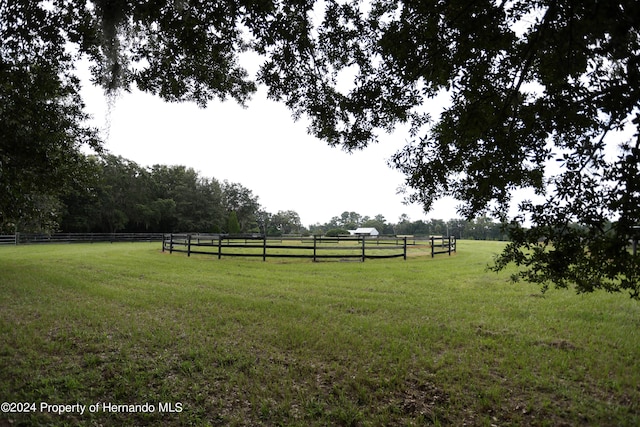 view of yard with a rural view and fence