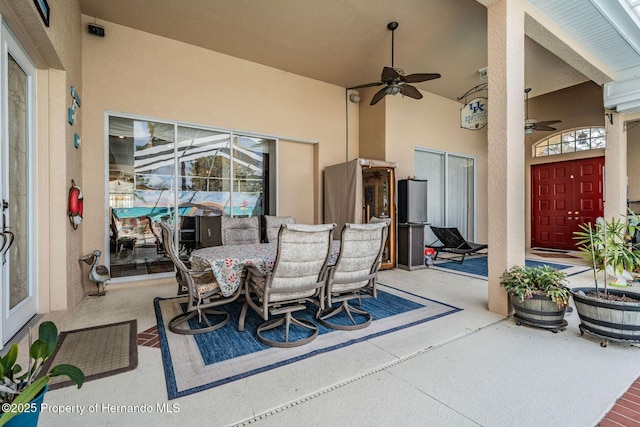 view of patio with outdoor dining area and a ceiling fan