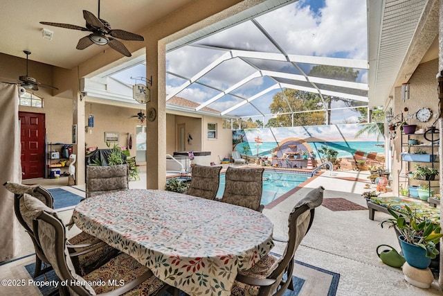 view of patio featuring a ceiling fan, glass enclosure, and an outdoor pool