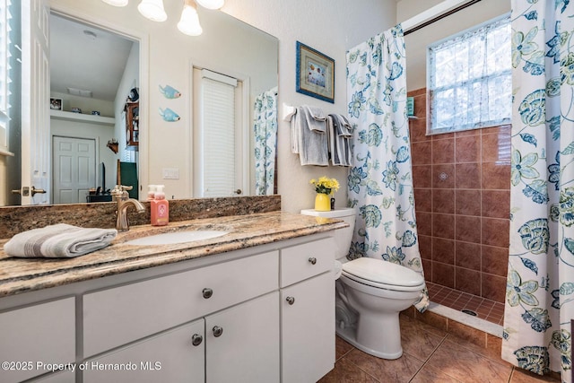 full bath with toilet, tile patterned flooring, tiled shower, and vanity