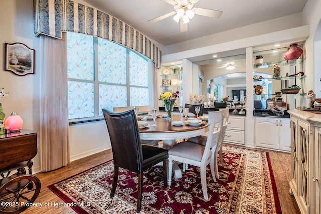 dining area with light wood finished floors, baseboards, and a ceiling fan