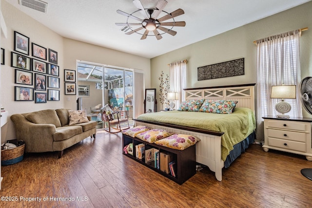 bedroom featuring access to exterior, a ceiling fan, visible vents, and hardwood / wood-style flooring