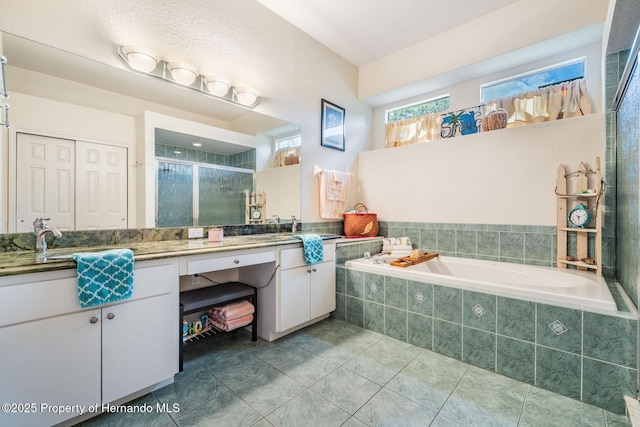 bathroom with tile patterned flooring, a shower stall, a bath, and vanity