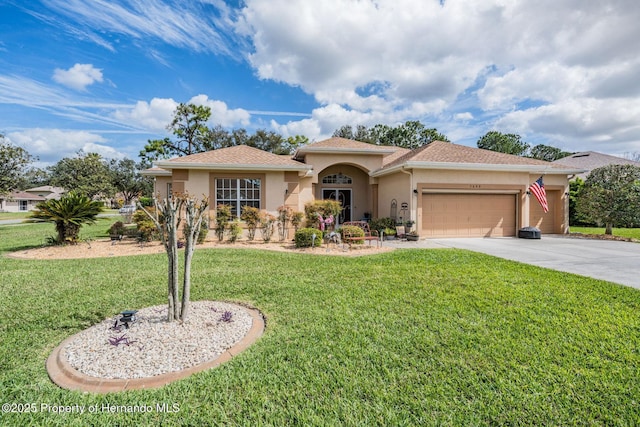 mediterranean / spanish house featuring concrete driveway, a front yard, an attached garage, and stucco siding