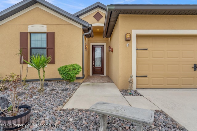 property entrance featuring an attached garage and stucco siding