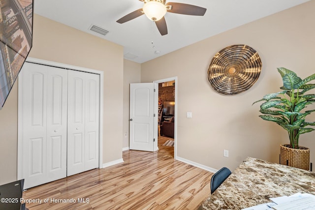 bedroom with a ceiling fan, visible vents, baseboards, a closet, and light wood finished floors