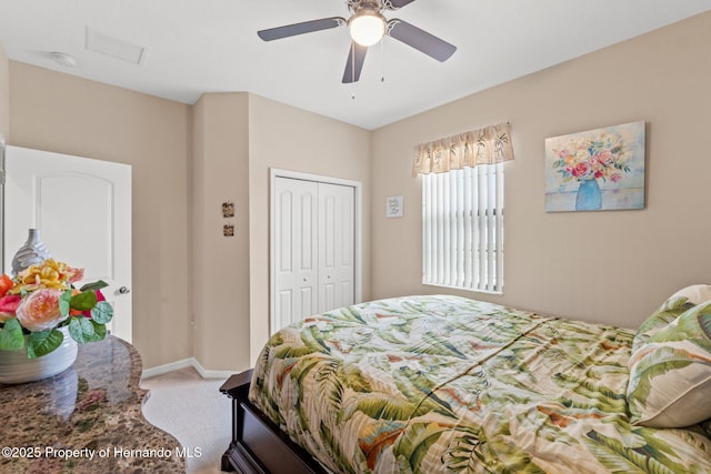 bedroom featuring a closet, light carpet, ceiling fan, and baseboards