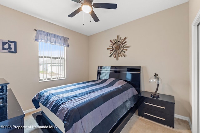 carpeted bedroom with ceiling fan and baseboards