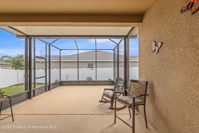 view of patio / terrace featuring a lanai and fence