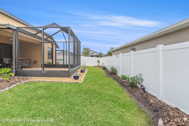 view of yard featuring glass enclosure and a fenced backyard