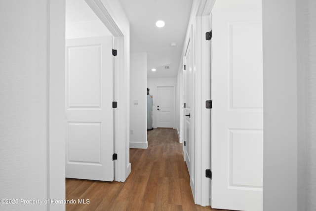 hallway with baseboards, wood finished floors, and recessed lighting