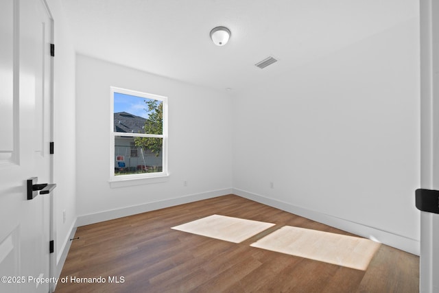 unfurnished bedroom featuring visible vents, baseboards, and wood finished floors