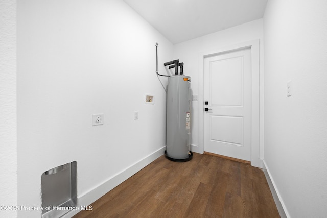 interior space featuring dark wood-type flooring, water heater, and baseboards