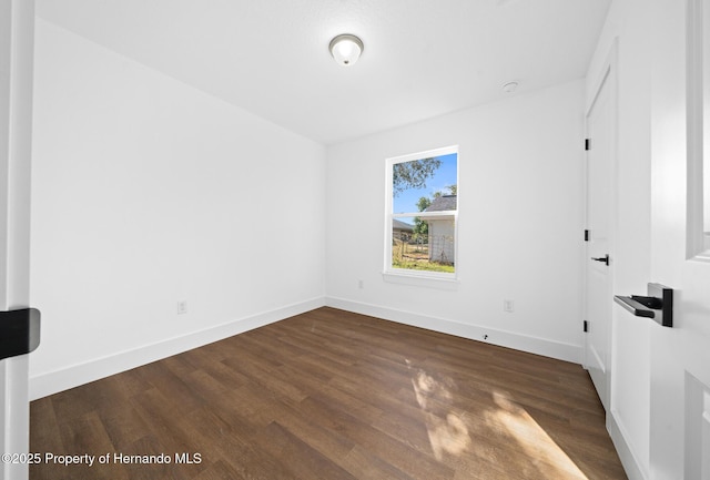 unfurnished bedroom featuring dark wood-type flooring and baseboards