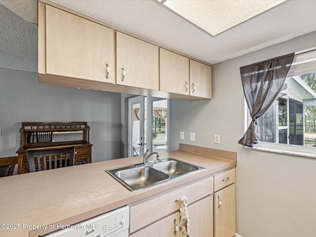 kitchen featuring light brown cabinets, light countertops, a sink, and dishwasher