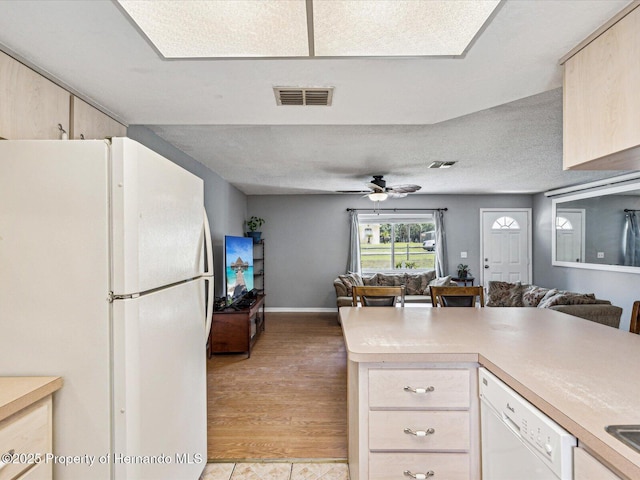 kitchen with light countertops, white appliances, visible vents, and open floor plan