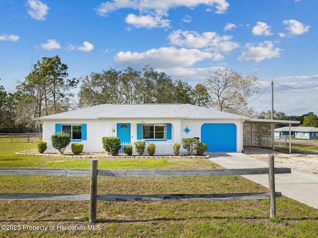 view of front of property with driveway, stucco siding, fence, and a front yard