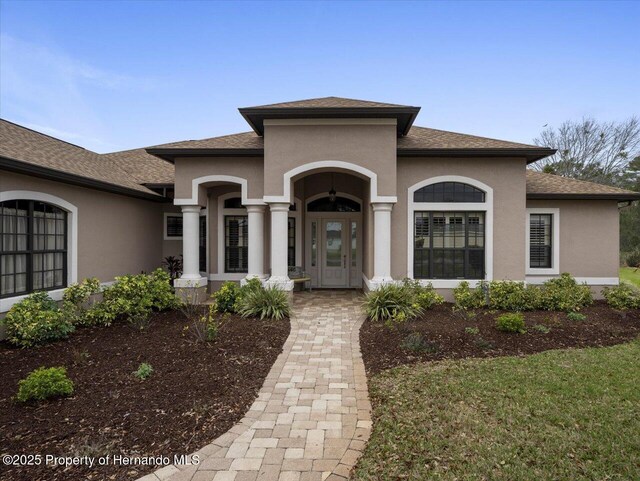 view of front of property featuring a shingled roof and stucco siding