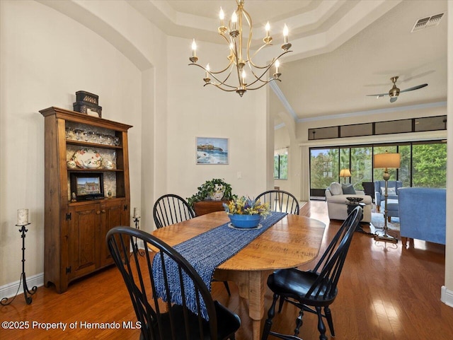 dining room with crown molding, visible vents, ceiling fan, wood finished floors, and baseboards