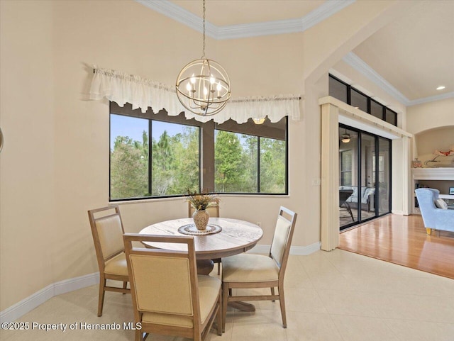 dining area featuring baseboards, ornamental molding, and an inviting chandelier