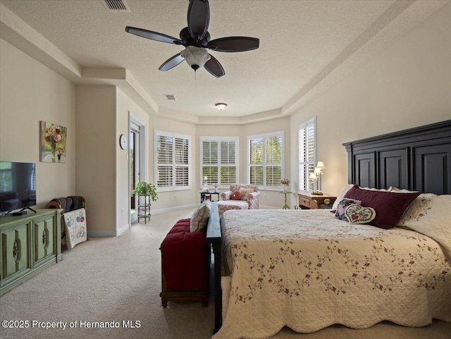 carpeted bedroom with a textured ceiling, ceiling fan, visible vents, and baseboards