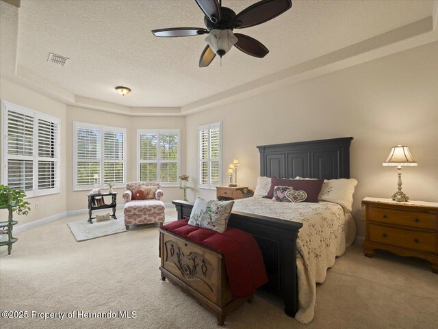 bedroom featuring visible vents, baseboards, a raised ceiling, a textured ceiling, and carpet flooring