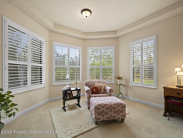 living area with baseboards, a healthy amount of sunlight, and carpet flooring