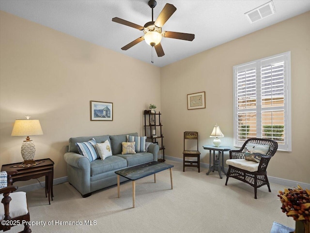 living room featuring light colored carpet, visible vents, ceiling fan, and baseboards