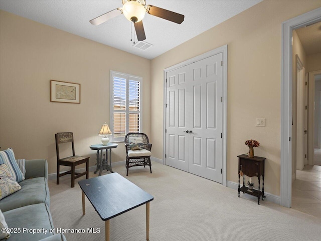 living area with ceiling fan, carpet, visible vents, and baseboards