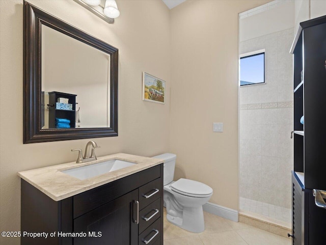 full bath with toilet, vanity, tiled shower, baseboards, and tile patterned floors