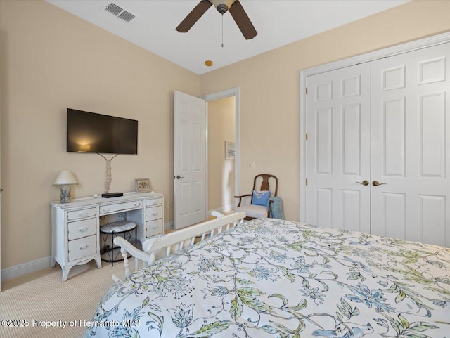 bedroom with baseboards, visible vents, a ceiling fan, light colored carpet, and a closet