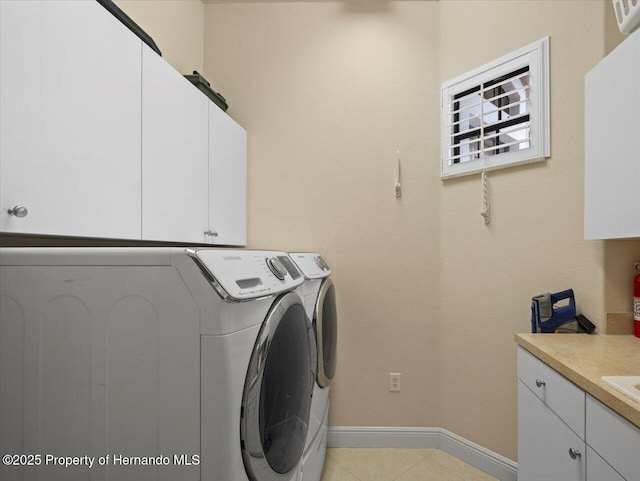 washroom with cabinet space, washer and clothes dryer, and baseboards