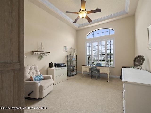 interior space featuring carpet floors, ornamental molding, a raised ceiling, and baseboards