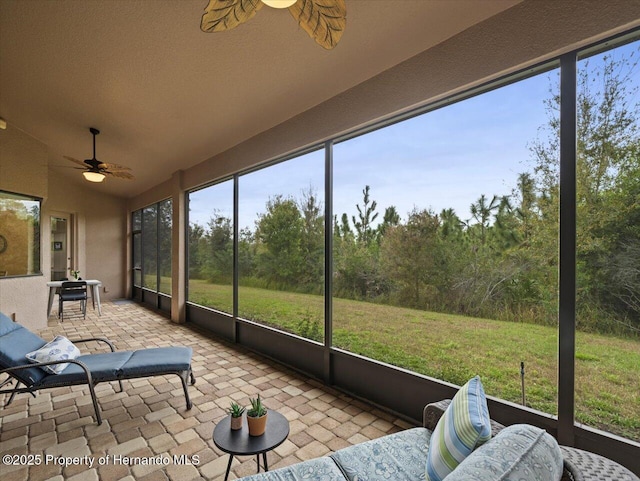 sunroom featuring ceiling fan and vaulted ceiling