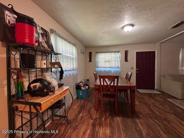 dining space with a textured ceiling and wood finished floors