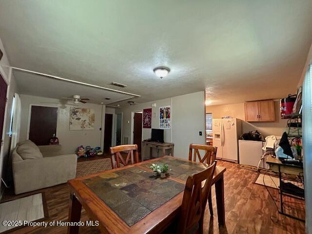 dining room featuring visible vents, ceiling fan, and light wood-style flooring