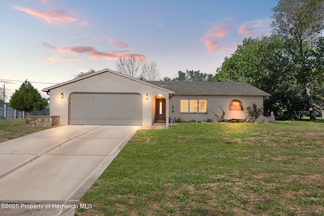 single story home with stucco siding, driveway, a garage, and a yard