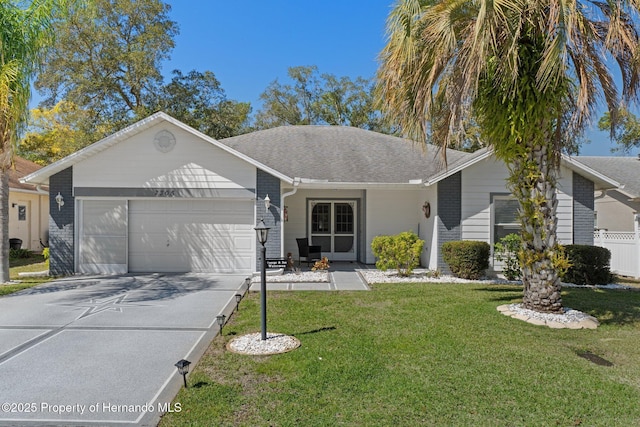 ranch-style house featuring a front yard, driveway, roof with shingles, an attached garage, and brick siding