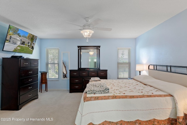 bedroom with multiple windows, light colored carpet, and ceiling fan