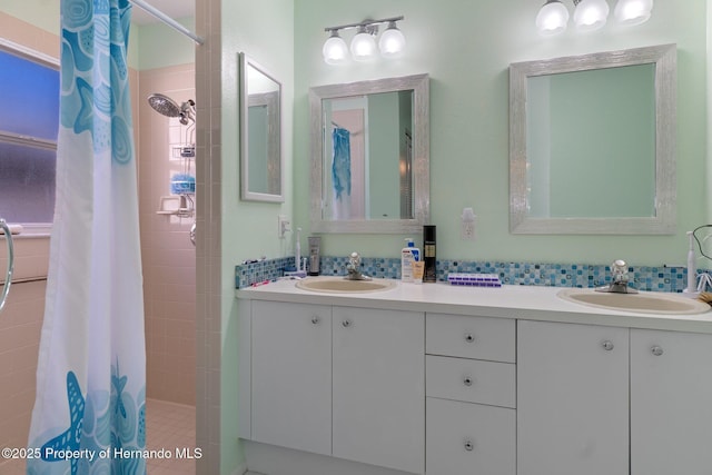 full bath with a sink, double vanity, and a tile shower