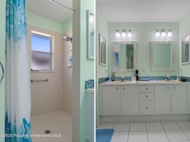 bathroom with a sink, tiled shower, and double vanity