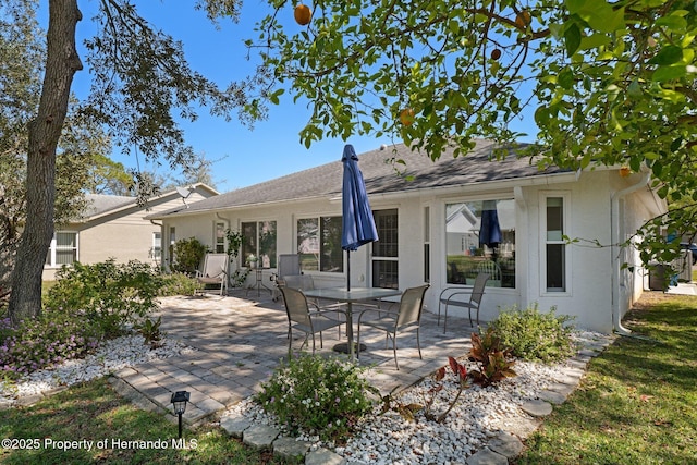 rear view of house featuring stucco siding and a patio